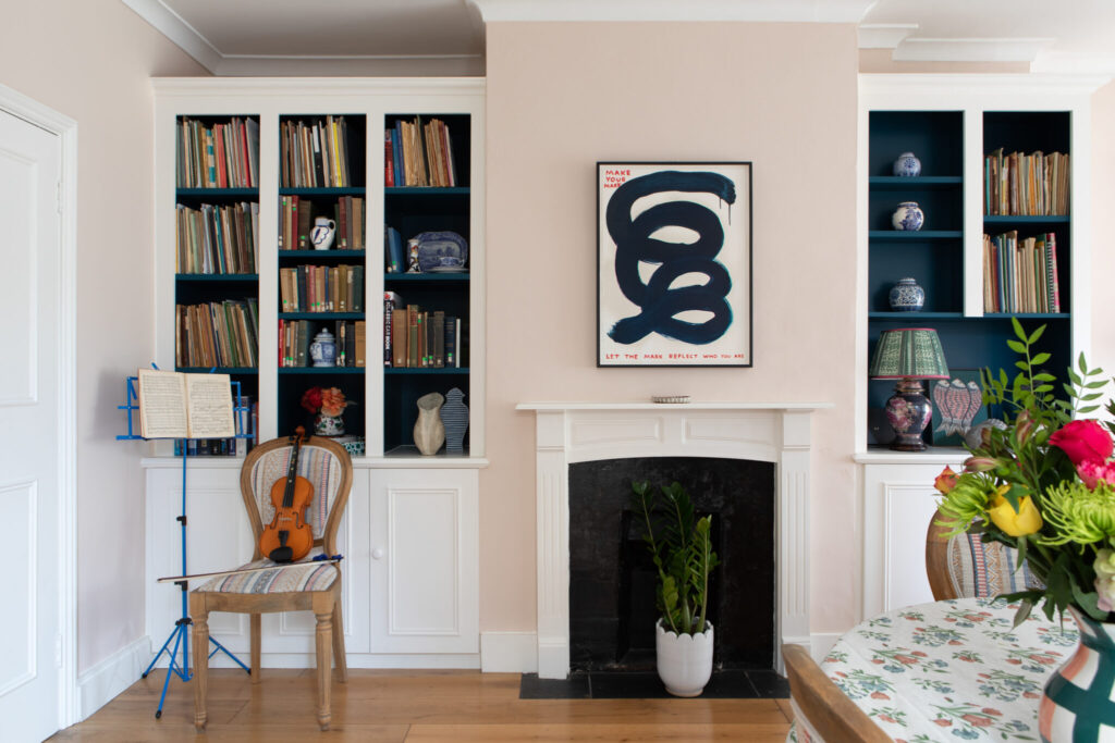 Barnes interior designer styled living room with dark blue and white book cases and art