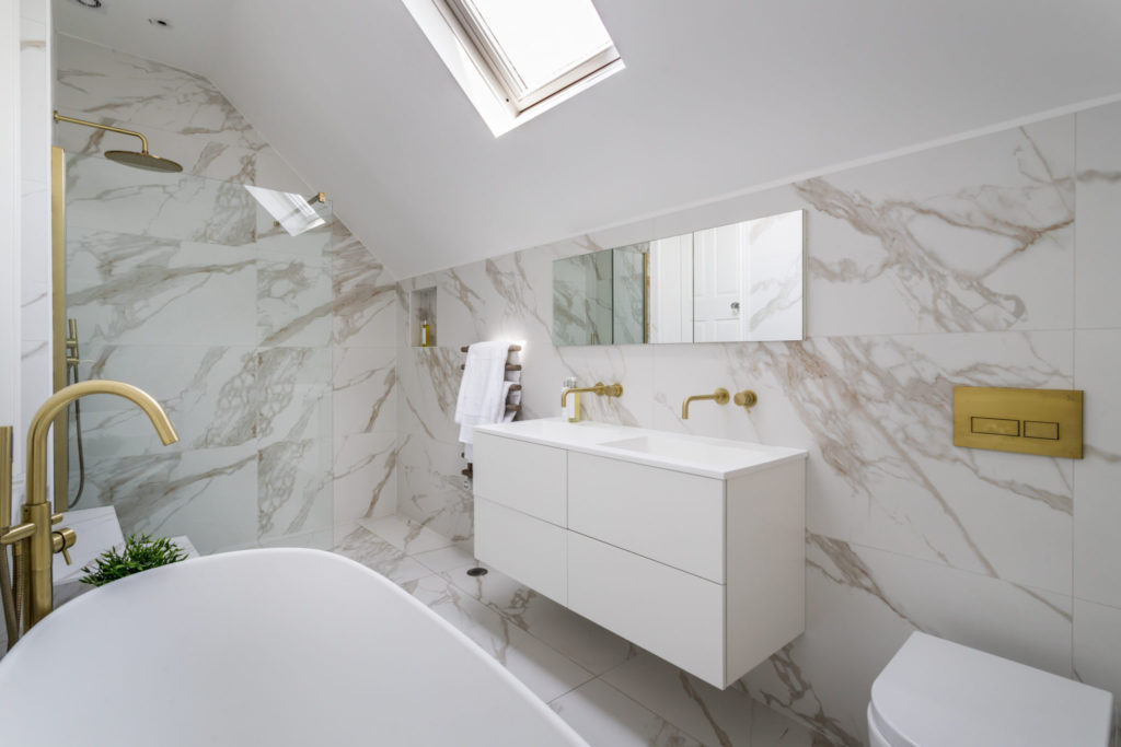 Surrey interior designer Amanda Delaney created luxury bathroom with marble effect porcelain tiles and contemporary brass tap details