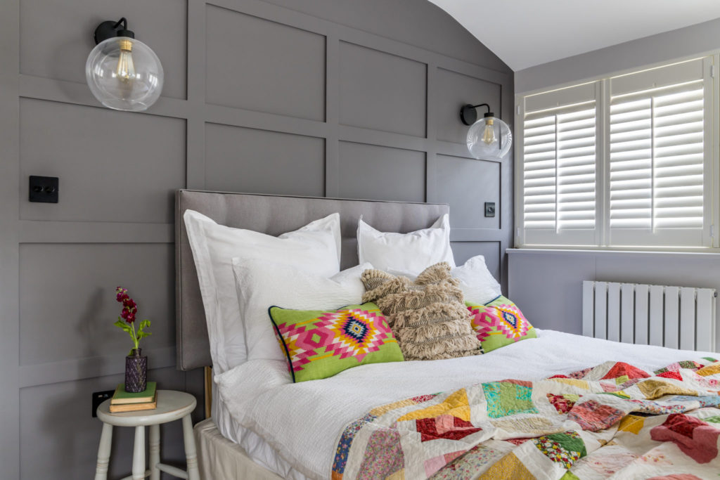 Surrey Interior Designer styled panelling wall in guest bedroom with grey paint and oka cushions
